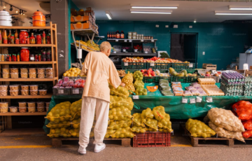 Image of a person selecting produce at a local convenience store.