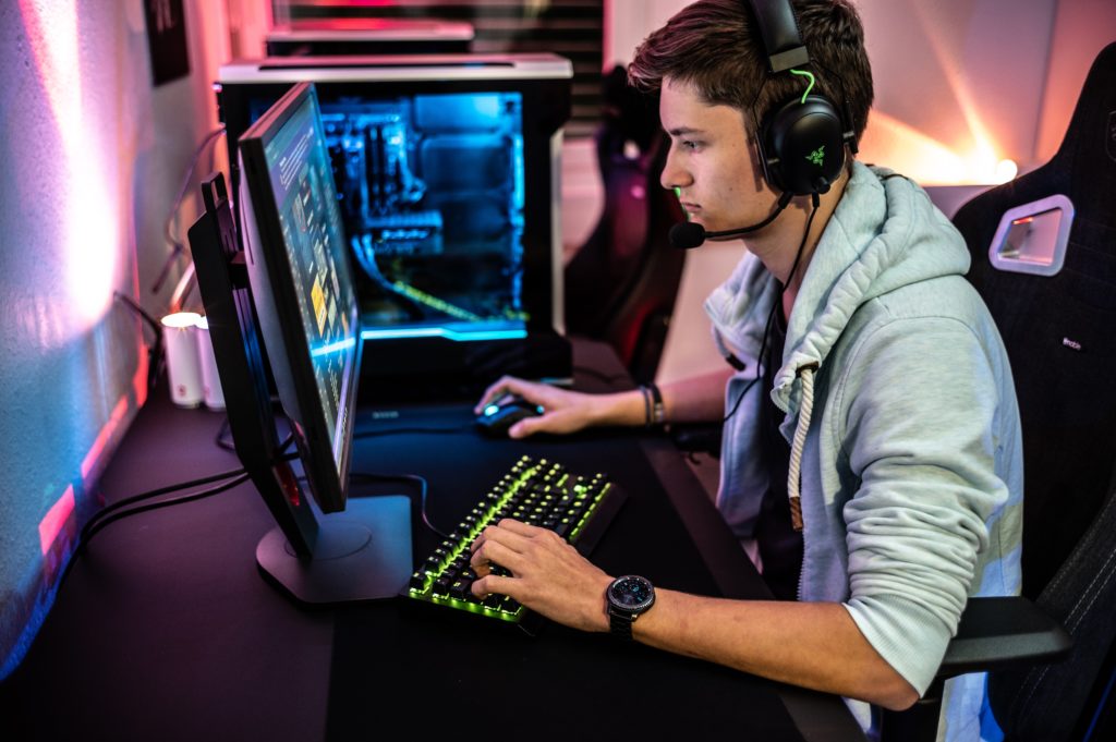 A photo of a man playing PV video game while wearing a Rzer gaming headset.