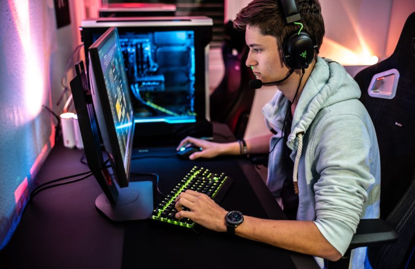 A photo of a man playing PV video game while wearing a Rzer gaming headset.