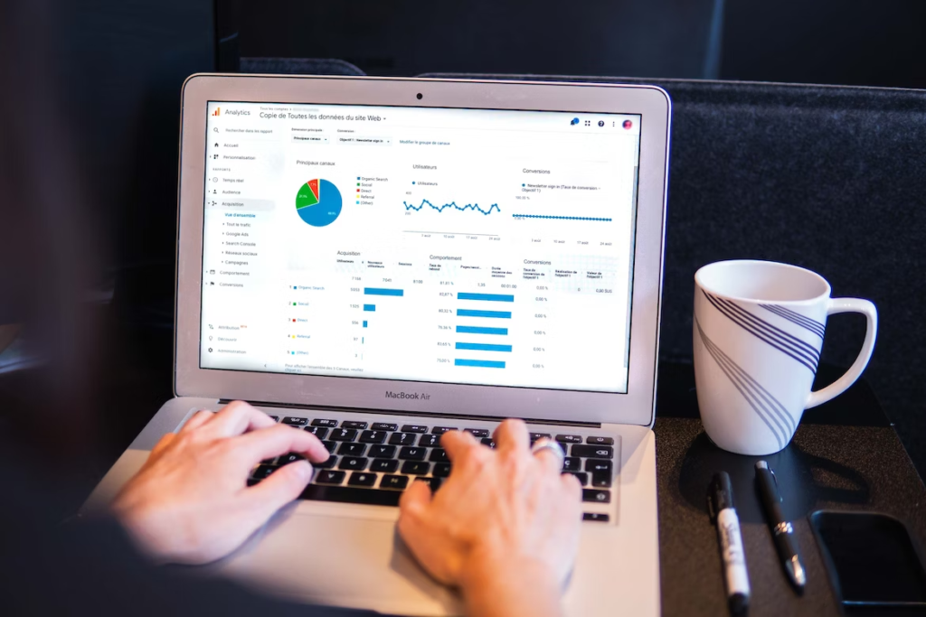 A shot of a man checking Google Analytics dashboard on a laptop.