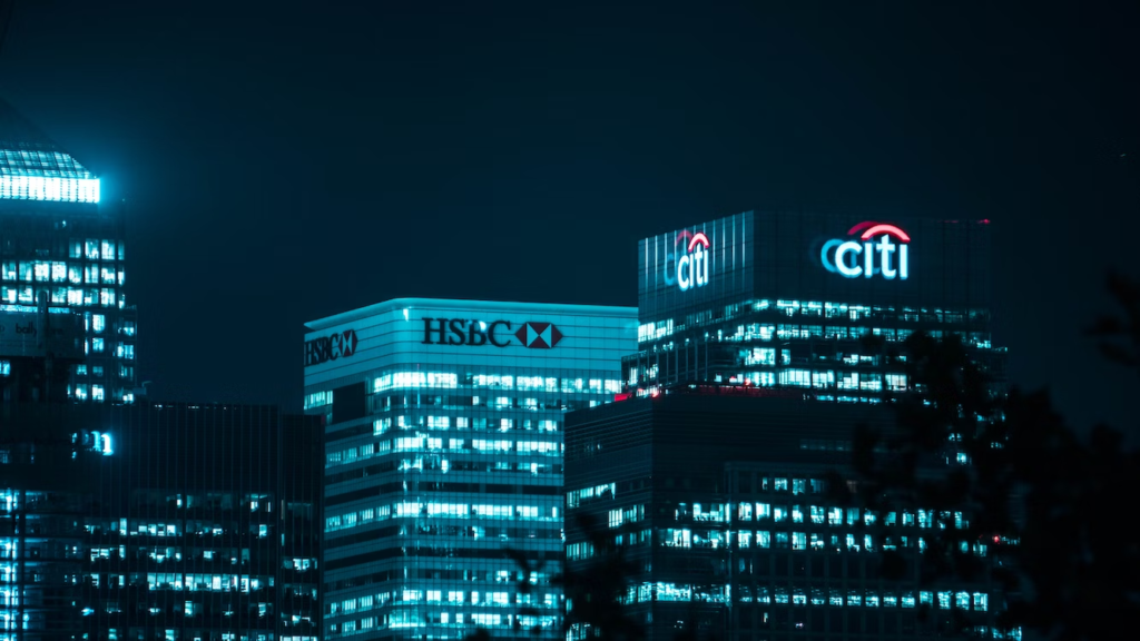 London skyline image at night showing the Citibank and HSBC buildings.