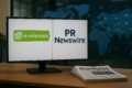 Monitor displaying eReleases and PR Newswire logos with PR Newswire newspapers on a desk in front.