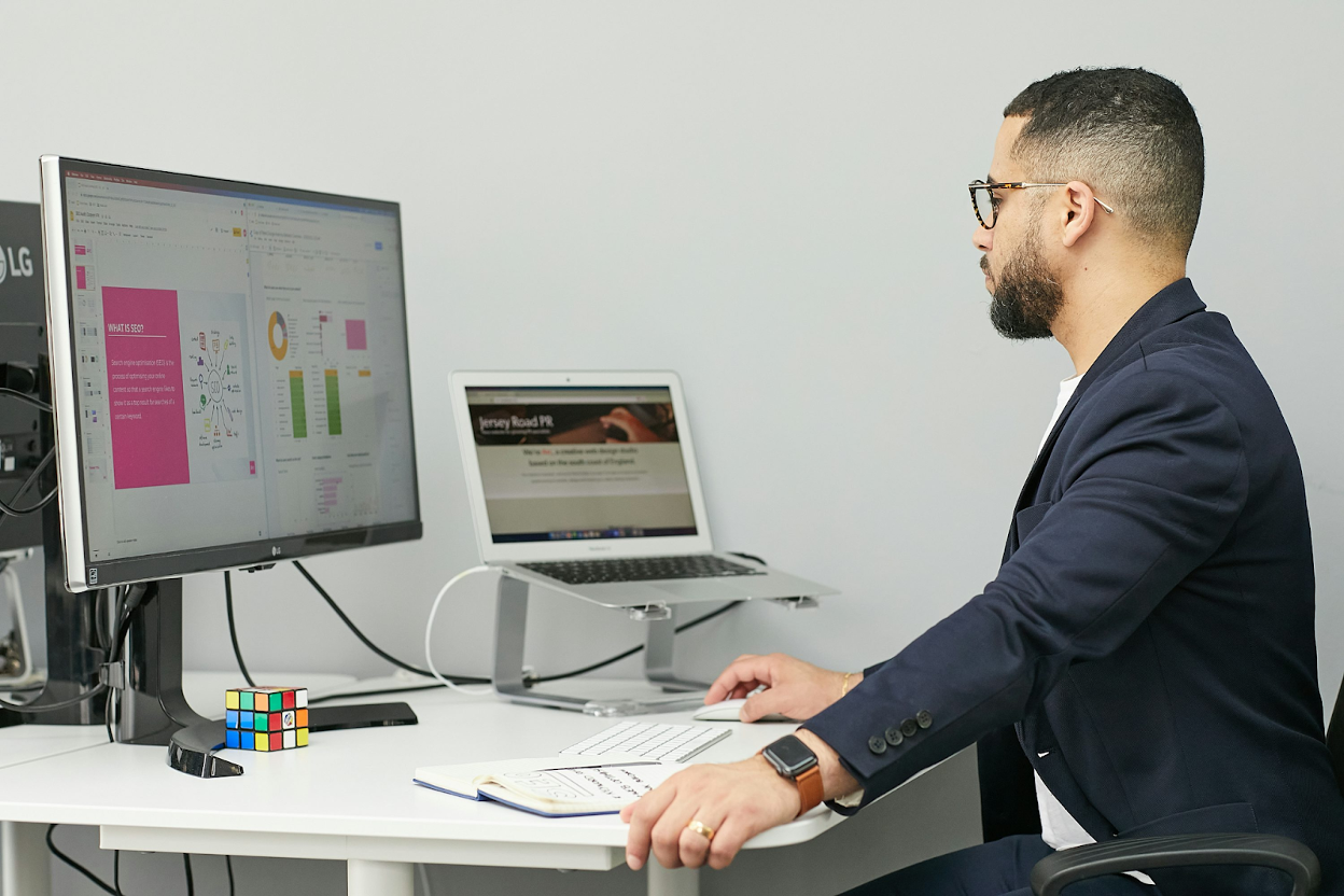 Professional comparing software dashboards on computer screens