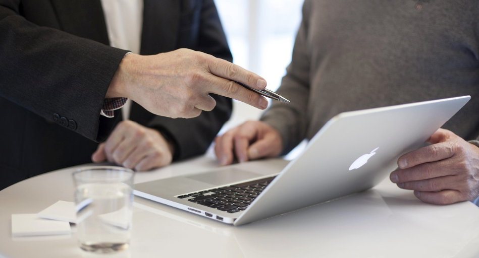 Two colleagues reviewing content strategy documents on a computer screen.