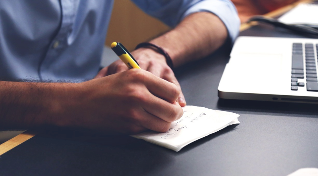 A person writing on a piece of paper.