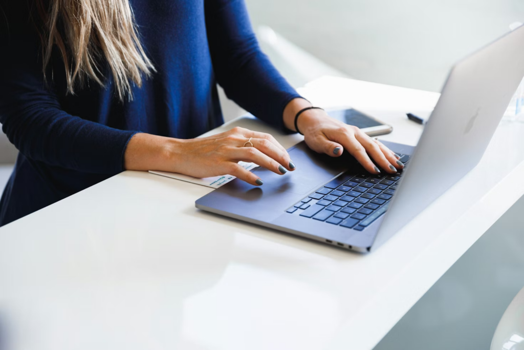 A woman typing a news story on a computer.
