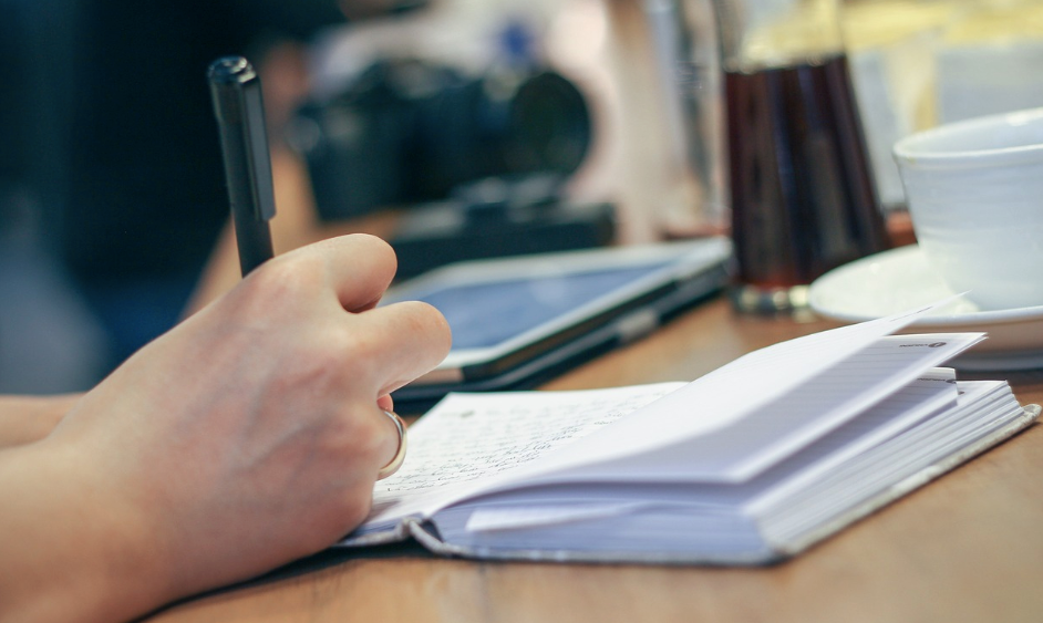 A person writing in a book.