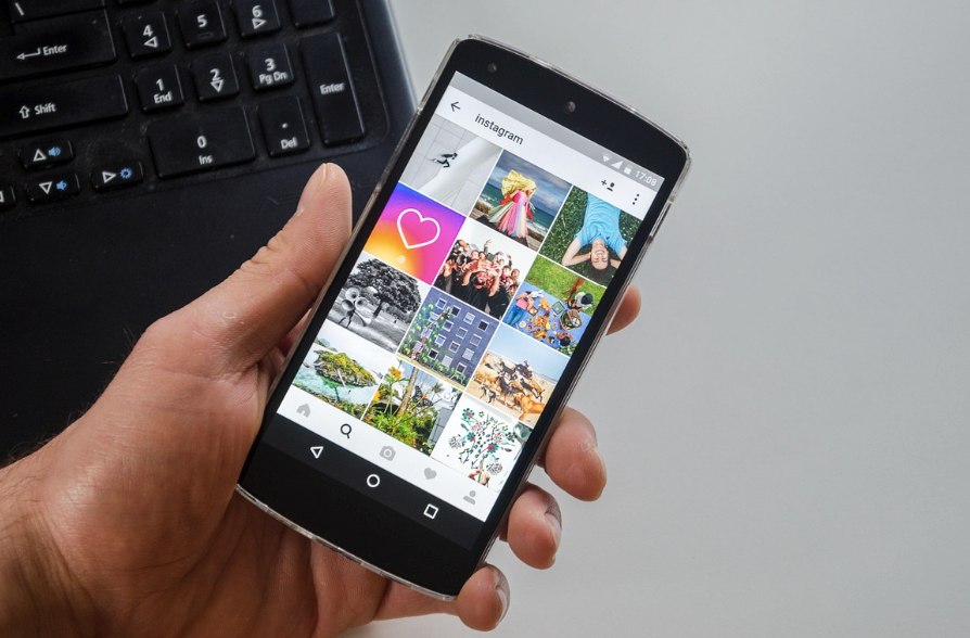A person holding a phone while scrolling through Instagram.