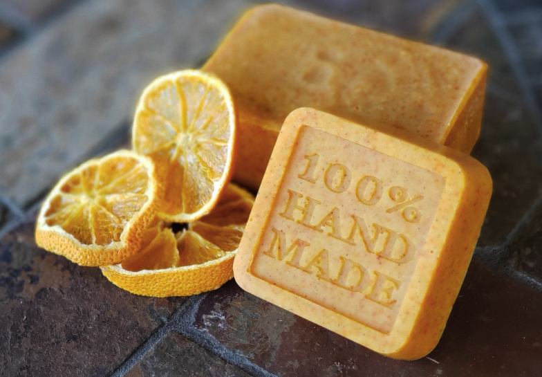 Handmade soap bar beside dried orange slices styled for a skincare product press release photo